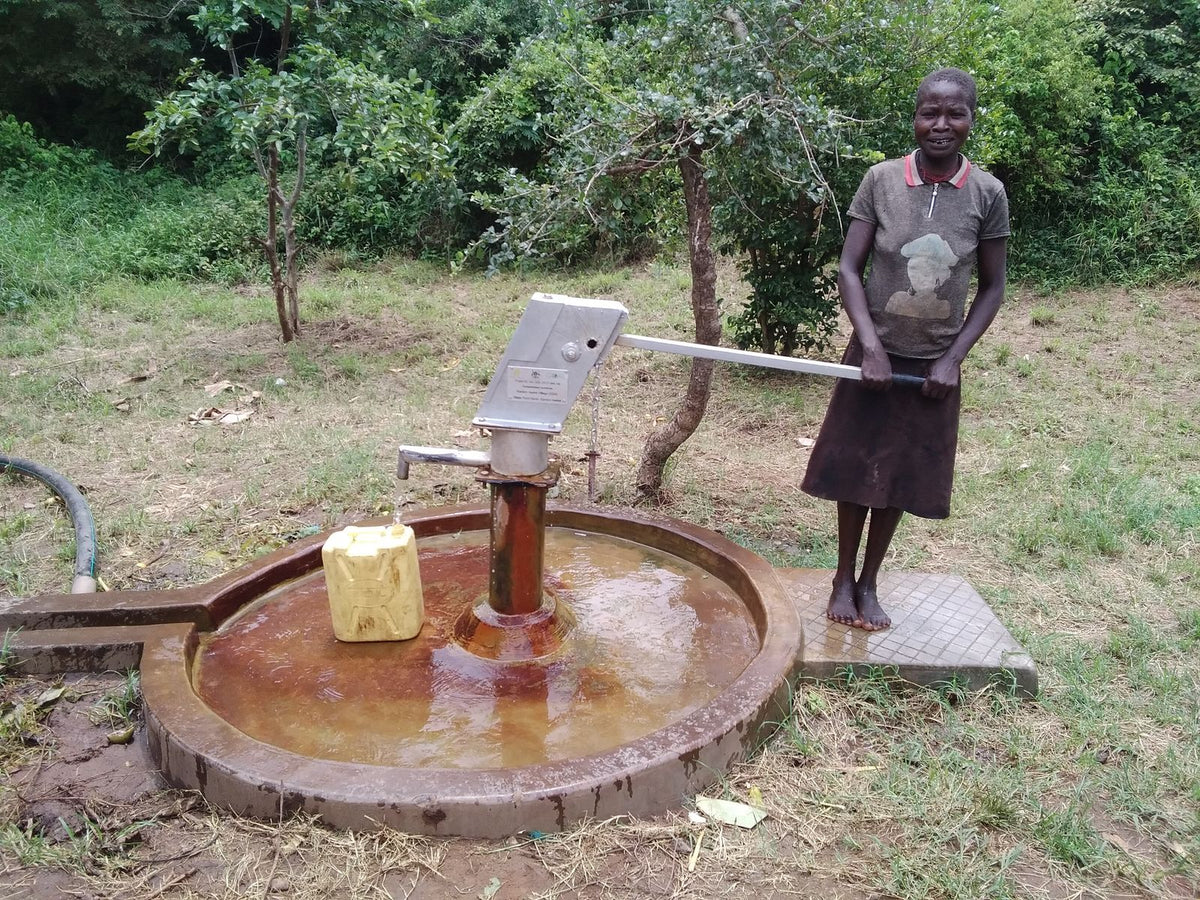 Well with hand pump in Kamion Market, Uganda, funded through charity: water